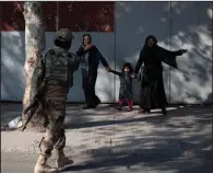  ?? (AP/Ahmad Halabisaz) ?? A Taliban fighter orders people away after an explosion and armed attack Tuesday at the entrance of a military hospital in Kabul.