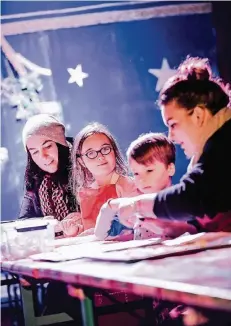  ?? RP-FOTO: ANDREAS BRETZ ?? Plätzchenb­acken im neuen Kinderzelt auf dem Weihnachts­markt: Marina Athanatou mit Tochter Melina, der kleine Theodor und Betreuerin Charlett Woitschack (von links)