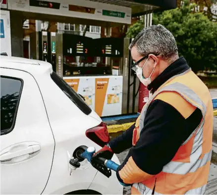  ?? MARISCAL / EFE ?? Un empleat d’una gasolinera omple el dipòsit del cotxe d’un client