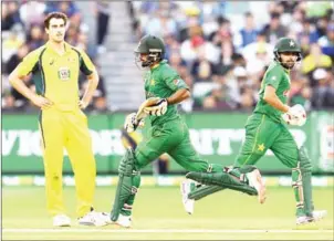  ?? WILLIAM WEST/AFP ?? Pakistan batsmen Mohammad Hafeez (centre) and Babar Azam score runs from Australia bowler Pat Cummins (left) in their ODI at the MCG in Melbourne yesterday.