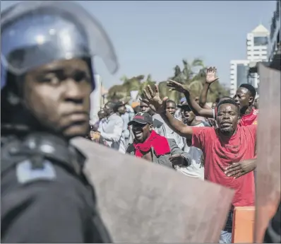  ??  ?? Police patrol outside the Zimbabwe Electoral Commission offices as opposition supporters gather in Harare, Zimbabwe.