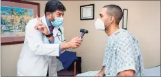  ??  ?? Dr. Khuram Ghumman directs patient Carlos Padilla where to look as he checks his eyes during an annual physical at East Granby Family Practice LLC where he is in private practice.