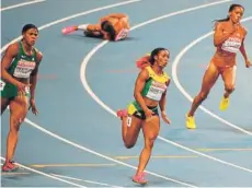  ?? FOTO: AFP ?? Shelly-Ann Fraser avanza a la meta mientras Allyson Felix yace desgarrada en la pista.