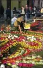  ?? GIOVANNA DELL’ORTO VIA AP ?? This photo shows a man creating a carpet with tropical flowers and rose petals in honor of the first of the elaborate Easter procession­s in Antigua, Guatemala. About 12 kilometers (7.5 miles) of cobbleston­e streets in the Central American city are...