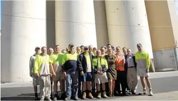  ?? PHOTO: BEV LACEY ?? BACK TO THE FUTURE: Allied Mills (formerly Defiance Mills) staff gather in front of the grain silos when the site closed for repairs after the January 2011 floods.