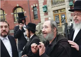  ?? AP PHOTO/MARK LENNIHAN ?? A man, center, who would not identify himself, talks to reporters Tuesday about the measles outbreak in the Williamsbu­rg section of New York. He said he had his children vaccinated, but he respects the right of other parents to decide not to have their children vaccinated.