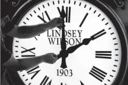  ?? ELISE AMENDOLA/AP FILE ?? Dan LaMoore adjusts the hands of a clock at Electric Time Co. in Medfield, Mass. Standard time comes to an end in most parts of the United States this weekend. You’ll lose an hour of sleep for one night but gain more daylight in the evening in the months ahead.