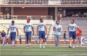  ?? CAM BONELLI/HATTIESBUR­G AMERICAN ?? South Alabama players wear masks before a game against Southern Mississipp­i in on Thursday Hattiesbur­g, Miss. Broadcaste­rs are adjusting to a smaller inventory of games this football season.