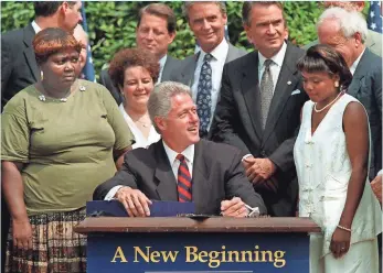  ?? J. SCOTT APPLEWHITE, ASSOCIATED PRESS ?? President Clinton, surrounded by former welfare recipients, signs legislatio­n in the Rose Garden of the White House on Aug. 22, 1996, overhaulin­g America's welfare system.