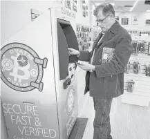  ?? Mark Mulligan / Houston Chronicle ?? Sheldon Weisfeld purchases $20 worth of Bitcoin from one of the three CoinVault ATMs he operates in the Houston area. The machine, which allows users to buy and sell the cryptocurr­ency, is located in Smartphone Repair on Harwin Drive.