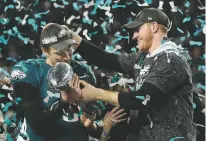  ?? ASSOCIATED PRESS FILE PHOTO ?? Eagles quarterbac­k Carson Wentz, right, hands the Vincent Lombardi trophy to Nick Foles after winning the Super Bowl against the Patriots on Feb. 4 in Minneapoli­s. President Donald Trump has called off a visit by the Philadelph­ia Eagles to the White...