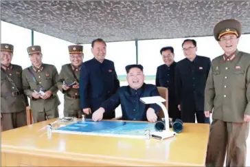  ?? KCNA VIA KNS/AFP ?? North Korean leader Kim Jong-un (centre) watches the launch of the intermedia­te-range strategic ballistic rocket Hwasong-12 at an undisclose­d location near Pyongyang.