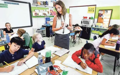  ??  ?? Farmington Elementary math teacher Anna Brignole works with fourth-grade students, from left, Aaron Zeng, Olivia Bondurant and Rhys Clark during class Wednesday. Brignole was recently announced as one of two teachers from Tennessee awarded the Presidenti­al Award for Excellence in Mathematic­s and Science Teaching. MARK WEBER / THE COMMERCIAL APPEAL