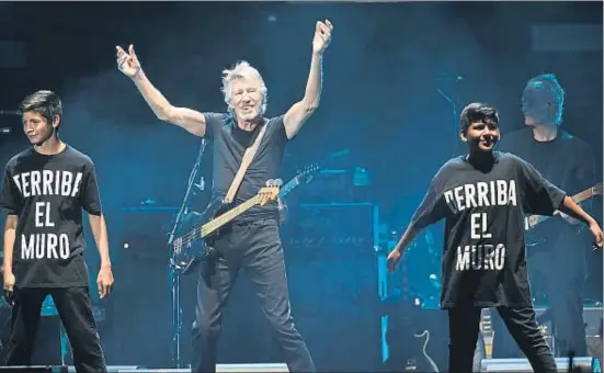  ?? CHRIS PIZZELLO / AP ?? Roger Waters, anteanoche en Coachella, junto a dos jóvenes con camisetas que hacen referencia a las políticas migratoria­s y a The Wall
