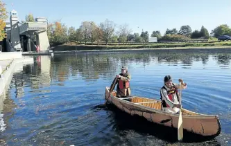  ?? CLIFFORD SKARSTEDT/EXAMINER FILE PHOTO ?? A ceremony celebrates Chuck Commanda's (front) constructi­on of a traditiona­l Gitigan Ziibi-style birch bark canoe with Stephen Hunter during a ceremony to launch the canoe on Oct. 3 at the Lift Lock, future site of the new Canadian Canoe Museum....