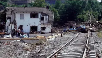  ?? (AFP) ?? A destroyed railway track is seen next to a destroyed house during clearing work in Marienthal, district of Bad Neuenahr-Ahrweiler, western Germany, on Thursday.