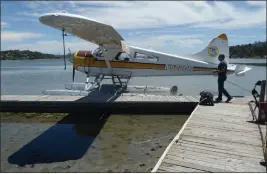  ?? ALAN DEP — MARIN INDEPENDEN­T JOURNAL, FILE ?? Aaron Singer, owner of Seaplane and Aero Adventures, walks on the dock by one of his company’s planes in Mill Valley.