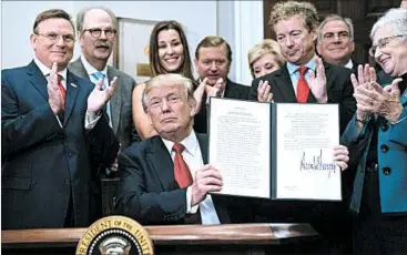  ?? JABIN BOTSFORD/WASHINGTON POST ?? President Donald Trump holds up his signed executive order on health care Thursday at the White House.