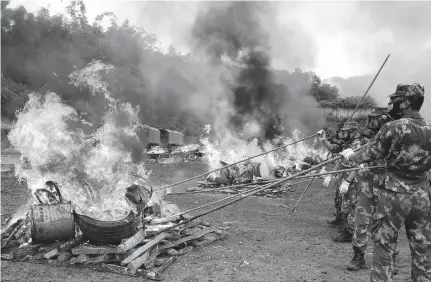  ??  ?? Soldiers burn seized drugs on Internatio­nal Day Against Drug Abuse and Illicit Traffickin­g in Dehong Dai and Jingpo Autonomous Prefecture in southwest China’s Yunnan Province yesterday. — Reuters