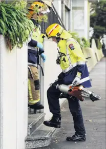  ??  ?? At the ready . . . A firefighte­r carries the jaws of life into Dunedin Hospital to free a contractor whose arm was stuck in an Xray machine.