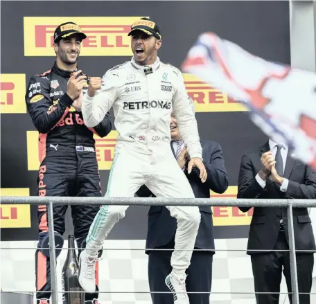  ?? Picture: EPA ?? PLEASED AS PUNCH: Lewis Hamilton celebrates his Belgium Grand Prix victory on the podium yesterday as Daniel Ricciardo, who finished in third place, applauds.