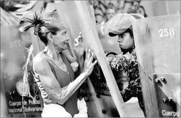  ??  ?? A woman confronts riot police during a protest against the shortage of food, amid Fuerzas Armadas avenue in Caracas. — AFP photo