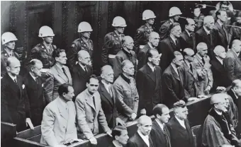  ??  ?? Nazi leaders accused of war crimes during World War II standing to hear the verdict in their trial, Nuremburg, October 2, 1946. Albert Speer is third from right in the back row of defendants; Karl Dönitz is at the far left of the same row. SS