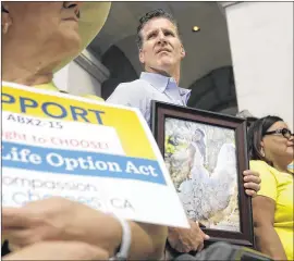  ?? RICH PEDRONCELL­I / ASSOCIATED PRESS ?? Dan Diaz holds a photo of his late wife, Brittany Maynard, taken on their wedding day, during a rally last month calling for California Gov. Jerry Brown to sign right-to-die legislatio­n at the Capitol in Sacramento, Calif.