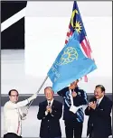  ?? (AFP) ?? Philippine­s Foreign Minister Alan Peter Cayetano (left), waves the Southeast Asian Games flag following the handover ceremony as next SEA Games hosts, during the closing ceremony of the 29th Southeast Asian Games (SEA Games) at Bukit Jalil Stadium
in...