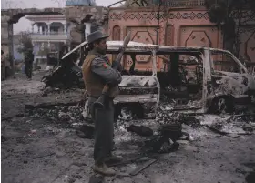  ?? Noorullah Shirzada / AFP / Getty Images ?? Security forces inspect the site of the attack on offices of Save the Children in Jalalabad. The organizati­on had been working in Afghanista­n since 1976.