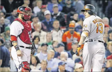  ??  ?? The Baltimore Orioles’ Manny Machado turns to look at Boston Red Sox catcher Sandy Leon after crossing home plate on his solo home run during the seventh inning Tuesday in Boston.