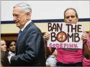  ?? GETTY IMAGES ?? Defense Secretary Jim Mattis walks past a protester as he arrives at a House Armed Services Committee hearing. The focus of the hearing was “The National Defense Strategy and the Nuclear Posture Review.”