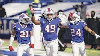  ?? John Munson / Associated Press ?? Buffalo’s Tremaine Edmunds , center, celebrates with Jordan Poyer, left, and Taron Johnson during their win over Baltimore in their Divisional Round game.