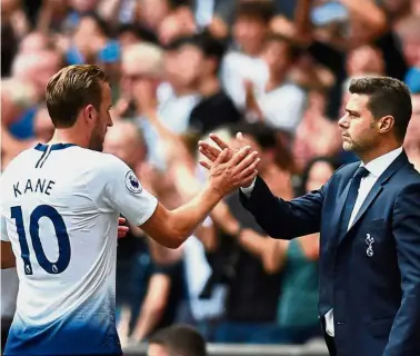  ?? — Reuters ?? Go make my day: Tottenham manager Mauricio Pochettino (right) shaking hands with striker Harry Kane during the Premier League match against Fulham last Saturday.