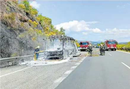  ?? ?? Bomberos apagan el fuego que calcinó por completo el autobús.