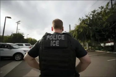  ?? GREGORY BULL — THE ASSOCIATED PRESS FILE ?? In this file photo, a U.S. Immigratio­n and Customs Enforcemen­t (ICE) officer looks on during an operation in Escondido Advocacy groups and unions are pressuring Marriott, MGM and others not to house migrants who have been arrested by U.S. Immigratio­n and Customs Enforcemen­t agents.