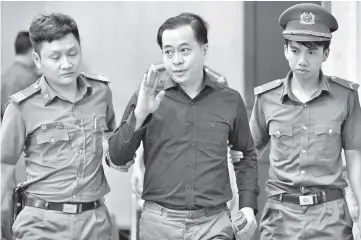  ??  ?? Vu is escorted by policemen during his trial in Ho Chi Minh city,Vietnam. — Reuters photo