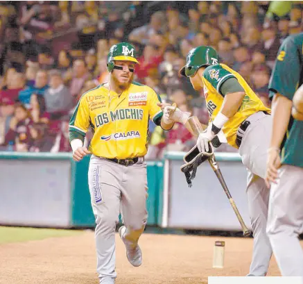  ??  ?? • Los jugadores de Los Mochis reciben a Esteban Quiroz tras anotar.