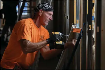  ?? ERIC BONZAR — THE MORNING JOURNAL ?? Dennis Wilhelm, of Wilhelm Constructi­on, installs metal framework on the second floor of the Lorain County Community Action Agency’s future home at 936 Broadway on April 20.