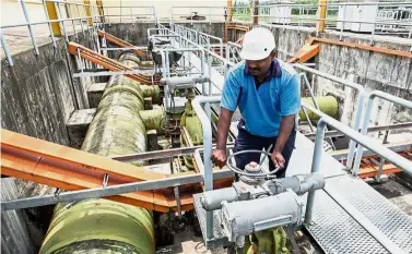  ??  ?? Monitoring pipes:
A worker checking a SPLASH water treatment plant.