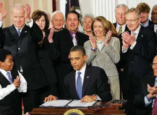  ?? Associated Press file photo ?? President Barack Obama signs the Affordable Care Act in 2010. President Joe Biden, then the vice president, has long been a strong supporter of the act.