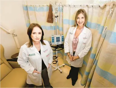  ?? AMY BETH BENNETT/SOUTH FLORIDA SUN SENTINEL PHOTOS ?? Dr. Alejandra Perez, left, and Dr. Carmen Calfa are shown with an infusion pump used to deliver chemothera­py at Sylvester Comprehens­ive Cancer Center in Plantation. The center just completed vaccine trials.