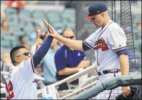  ?? DANIEL SHIREY / GETTY IMAGES ?? First base coach Eddie Perez highfives Sean Newcomb after the rookie pitcher came out of his major league debut in the seventh inning. Newcomb said afterward he “expected more” jitters.