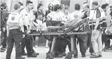  ??  ?? A victim is stretchere­d along a platform at the Estacio de Franca (Franca station) in central Barcelona. — AFP photo