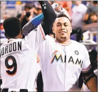  ?? MARK BROWN — GETTY IMAGES ?? Giancarlo Stanton of the Marlins celebrates with Dee Gordon in the dugout after hitting a home run, his league-leading 44th of the season, in the third inning against the Giants at Marlins Park on Tuesday. It was Stanton’s sixth straight game with a...