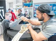  ?? PHOTO COURTESY OF COMCAST ?? WWE wrestler Seth Rollins greets fans at the Xfinity Store at Assembly Square.