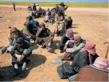  ??  ?? Men, including suspected Isis fighters, wait to be screened outside Baghouz.