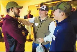  ?? ADOLPHE PIERRE-LOUIS/JOURNAL ?? Rio Rancho high school football star Josh Foley, left, talks with his father, Dan Foley, center, and brother, Tristen Foley, at Monday’s New Mexico State basketball game in Rio Rancho. Foley will be signing to play for NMSU on Wednesday.