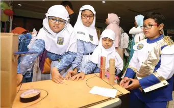  ?? DIKA KAWENGIAN/JAWA POS ?? BELAJAR DAN BERMAIN: Dari kiri, Alfi Rofida, Melly Zahra, Alfina Azzahra, dan Fachri Hamdani bermain point of ball di pameran peraga edukasi SD Muhammadiy­ah 18 Surabaya kemarin.