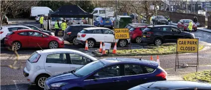  ??  ?? Waiting game: Queues at a testing unit in a car park in Saltcoats, Ayrshire, which opened yesterday